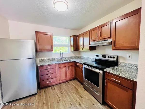 a kitchen with stainless steel appliances granite countertop a refrigerator sink stove microwave and cabinets