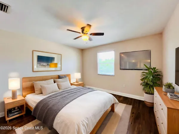 a bedroom with a bed and a potted plant