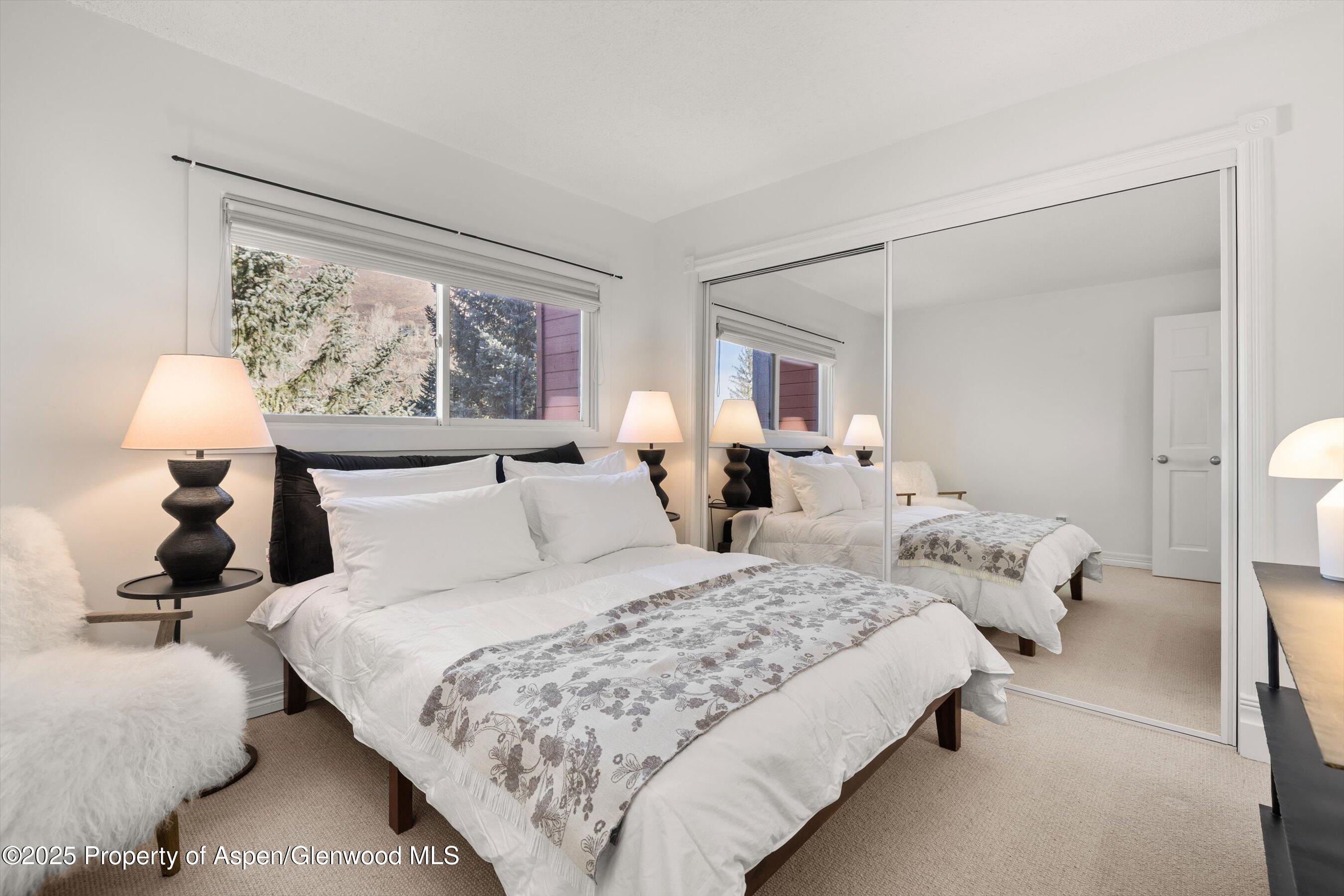 1041 Vine Street Aspen, CO 81611 - Photo 4 of 9 a bedroom with bed window and lamp on table