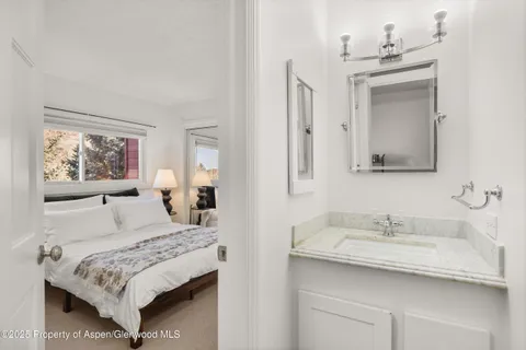 a bedroom with a sink and a mirror