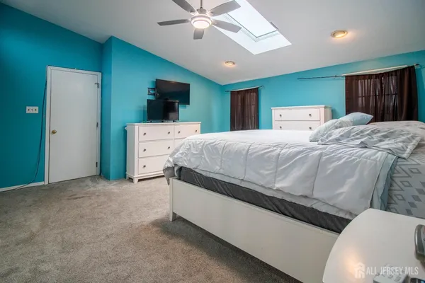 a spacious bedroom with a bed and a large mirror