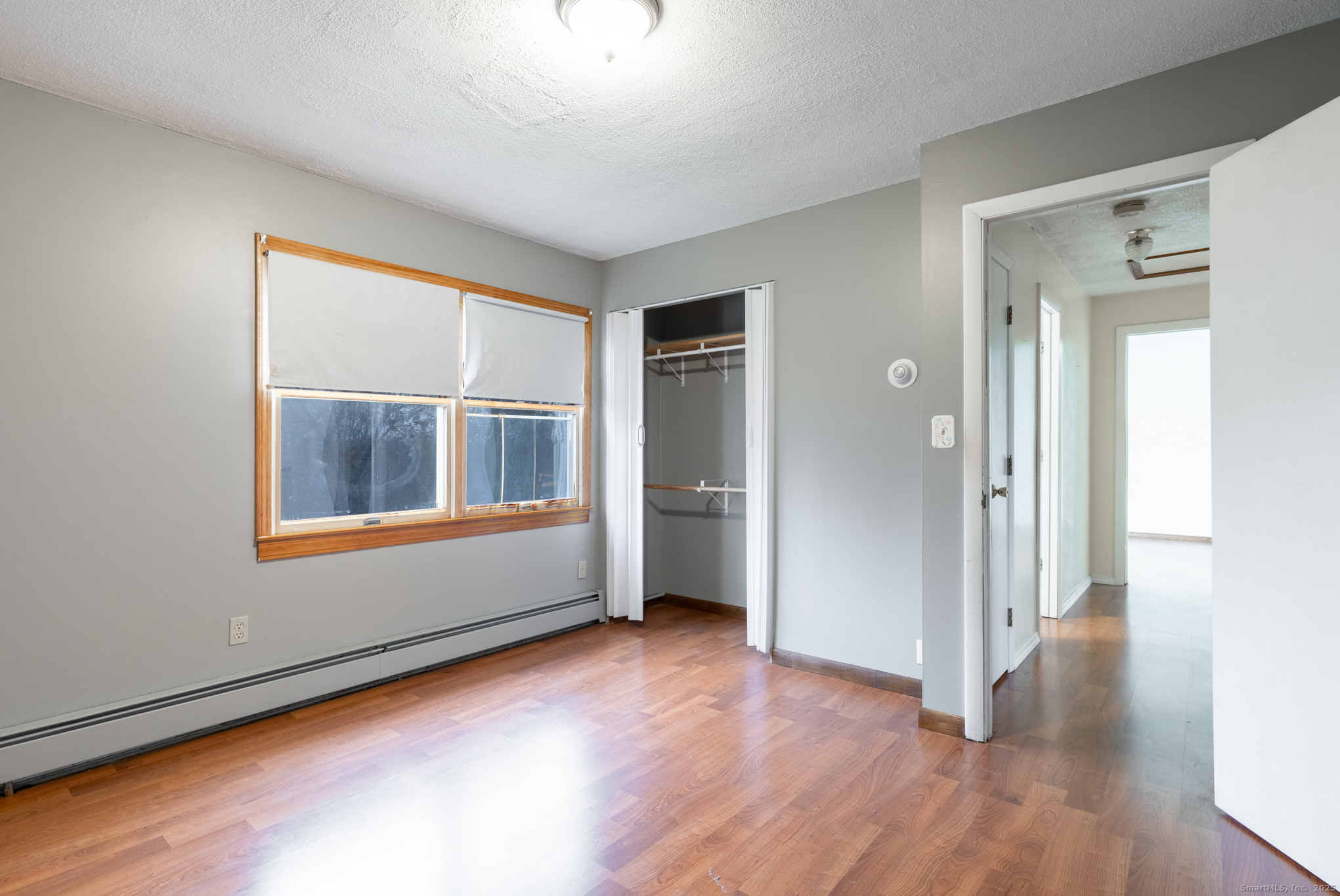 93 Tawny Thrush Road Naugatuck, CT 06770 - Photo 20 of 33 an empty room with wooden floor and windows