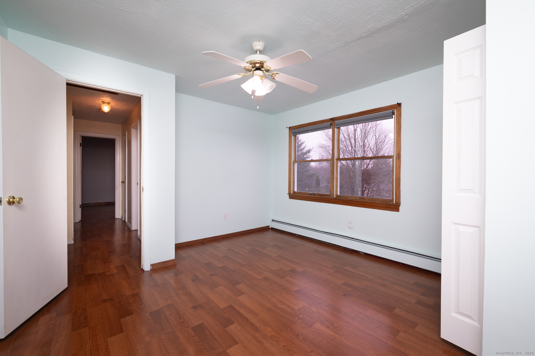 93 Tawny Thrush Road Naugatuck, CT 06770 - Photo 24 of 33 an empty room with wooden floor chandelier fan and windows