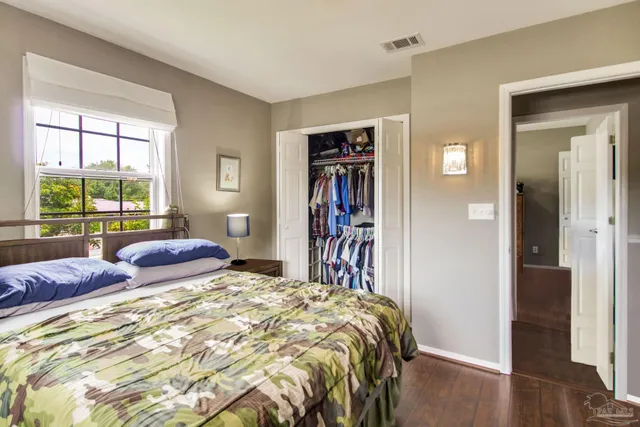 a bedroom with a bed and a large window