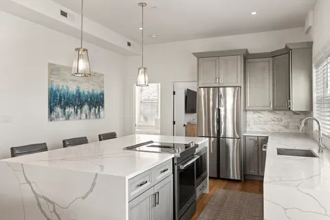 a kitchen with stainless steel appliances a sink stove and refrigerator