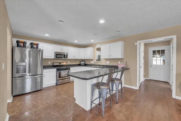 a kitchen with stainless steel appliances granite countertop a refrigerator and a stove top oven