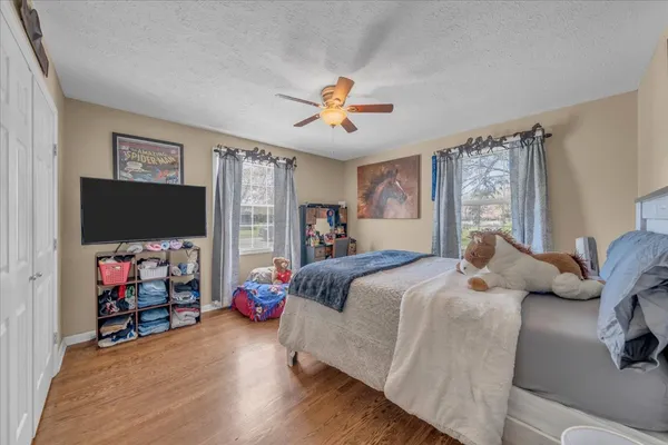 a bedroom with a bed and a flat tv screen on the dresser