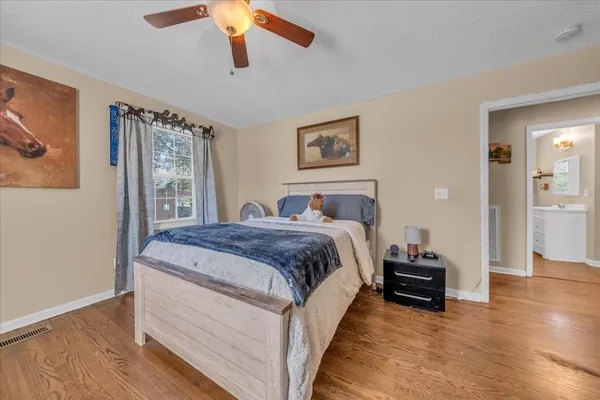 a bedroom with bed and wooden floor