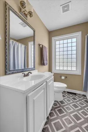 a bathroom with a sink a toilet and a mirror