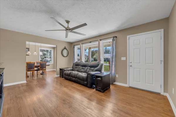 a living room with furniture and a wooden floor