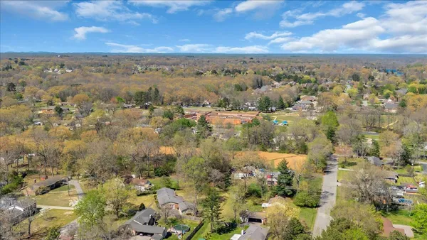 an aerial view of residential houses with outdoor space and trees