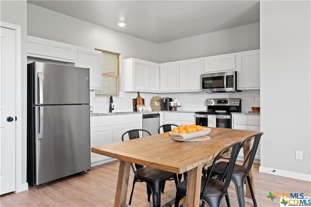 746 Meiomi Drive Temple, TX 76502 - Photo 4 of 32 a kitchen with stainless steel appliances a refrigerator a stove a dining table and chairs