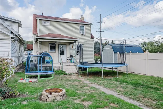 a view of a chair and table in backyard of the house