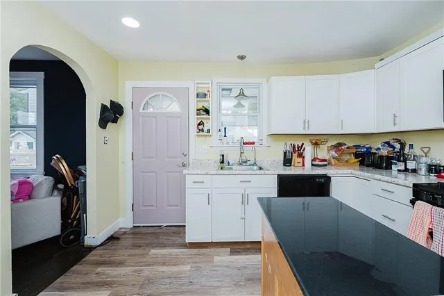 a kitchen with granite countertop white cabinets and white appliances