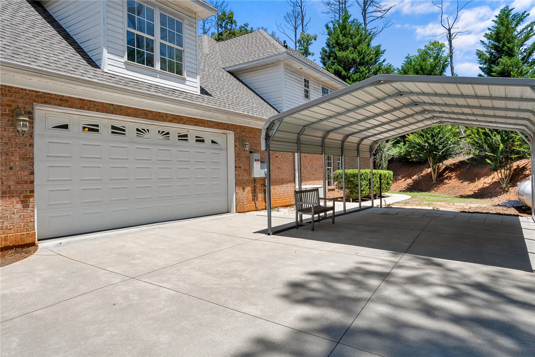 135 Sunset Bay Boulevard Seneca, SC 29672 - Photo 47 of 50 A spacious driveway leads to a two-car garage and a substantial carport, offering ample protected parking.
