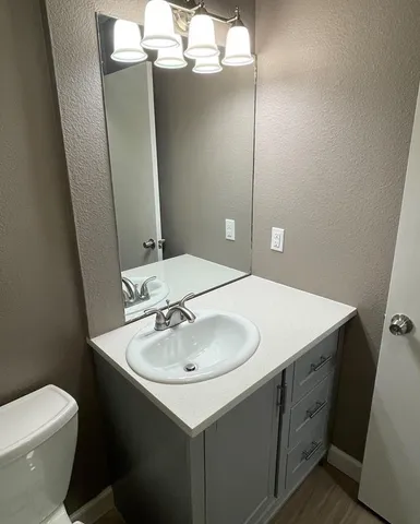 a bathroom with a sink and mirror with toilet