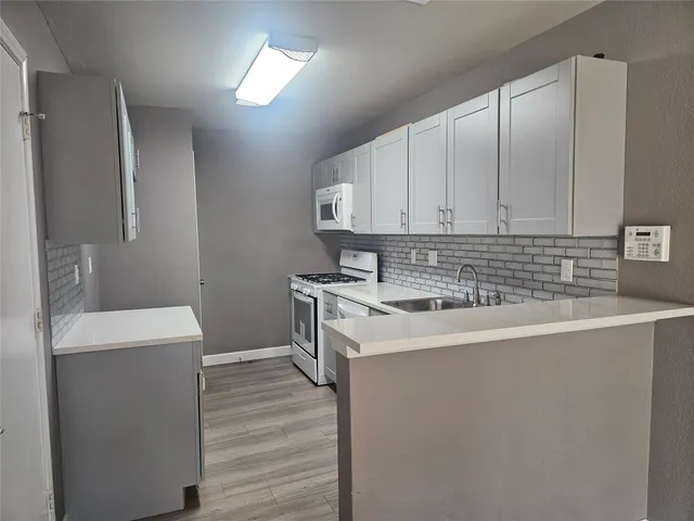 a kitchen with a sink cabinets and wooden floor