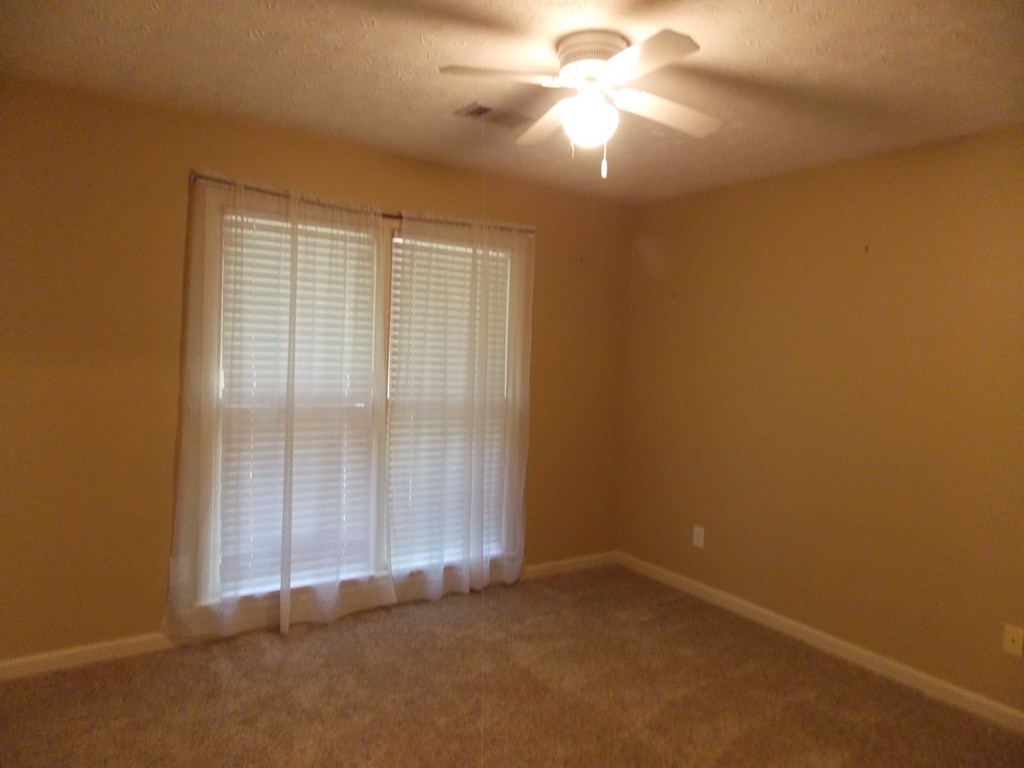 562 Evergreen Drive Fortson, GA 31808 - Photo 13 of 17 an empty room with a empty space and a ceiling fan
