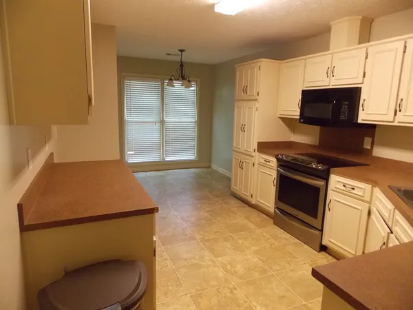 a kitchen with a sink a stove and cabinets