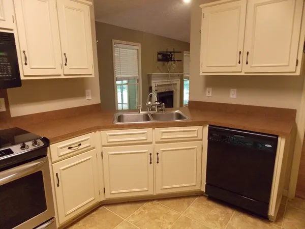 a kitchen with granite countertop white cabinets and white appliances