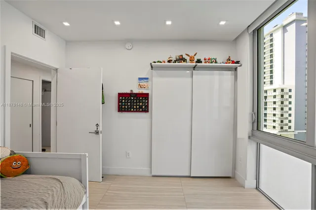 a view of a hallway to room with wooden floor