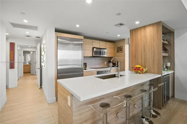 a kitchen with stainless steel appliances a stove a sink a refrigerator and cabinets