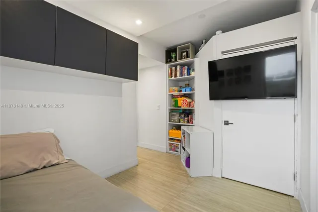 a view of a livingroom with wooden floor and a flat screen tv