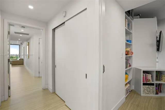 a view of a hallway with wooden floor and closet