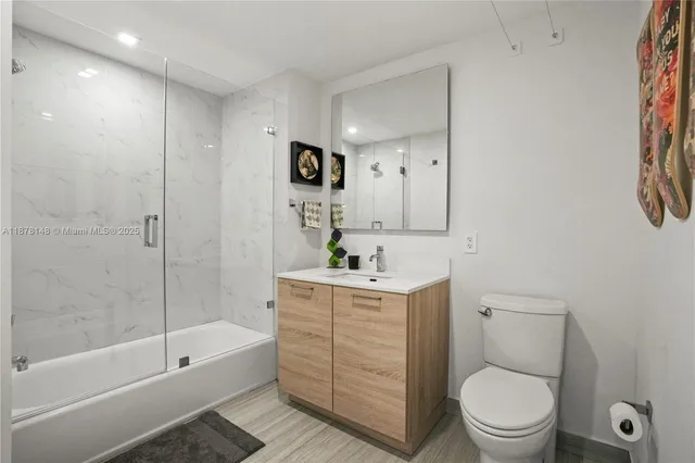 a bathroom with a granite countertop toilet a sink and bathtub