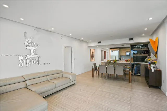 a living room with furniture a flat screen tv and a wooden floor