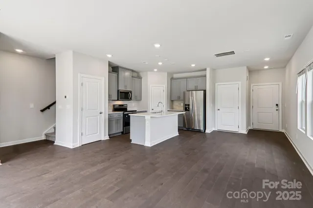 a view of a kitchen with refrigerator and white cabinets