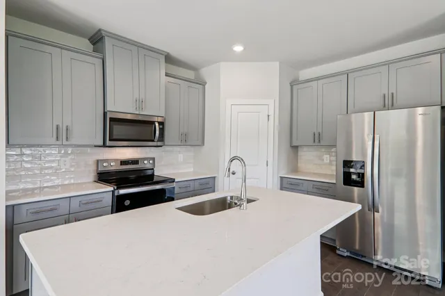 a kitchen with stainless steel appliances a refrigerator stove microwave and sink