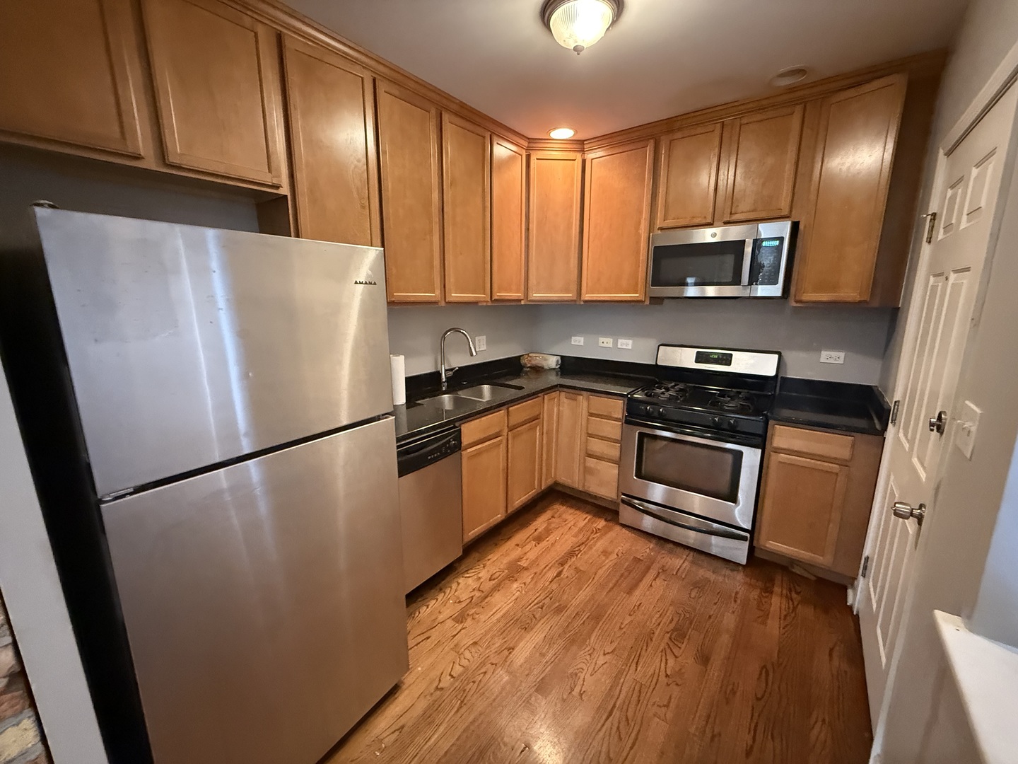 2704 West Arthur Avenue, Unit 3S Chicago, IL 60645 - Photo 2 of 11 a kitchen with stainless steel appliances granite countertop a refrigerator a stove a sink dishwasher and a microwave