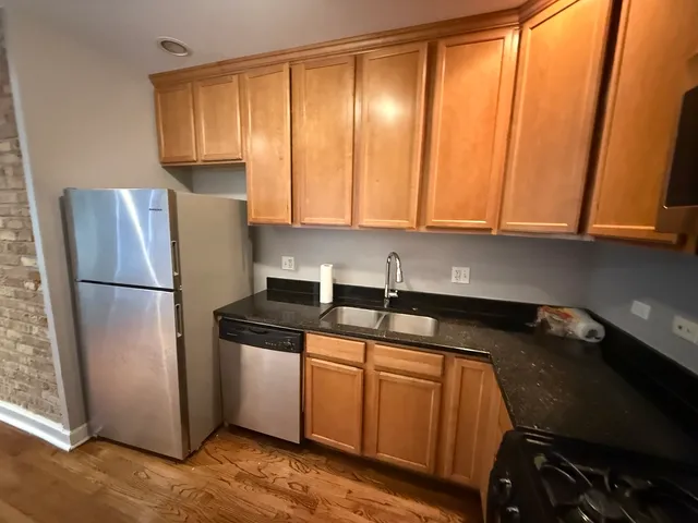 a kitchen with a sink a refrigerator and cabinets