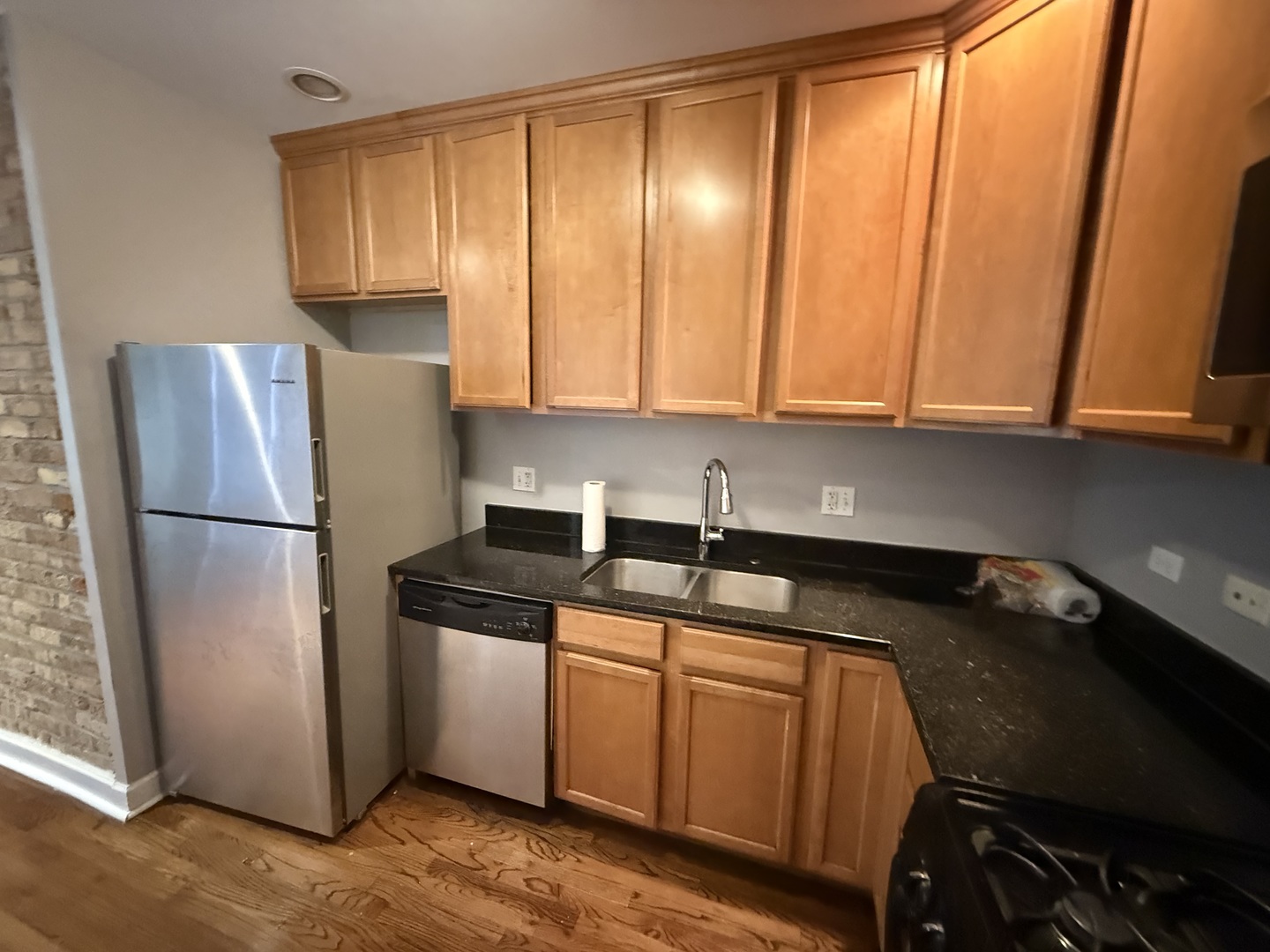 2704 West Arthur Avenue, Unit 3S Chicago, IL 60645 - Photo 3 of 11 a kitchen with a sink a refrigerator and cabinets