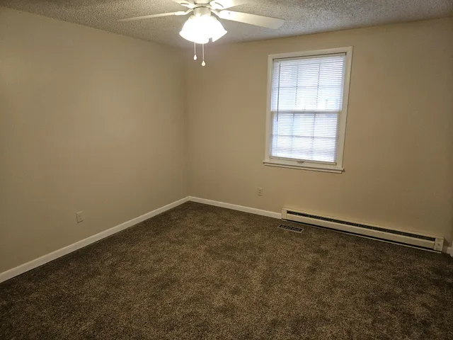 an empty room with a chandelier fan