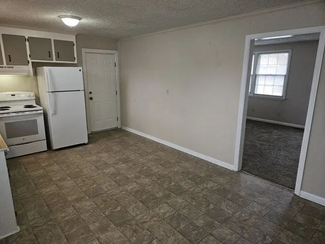 a view of kitchen with refrigerator cabinets and wooden floor