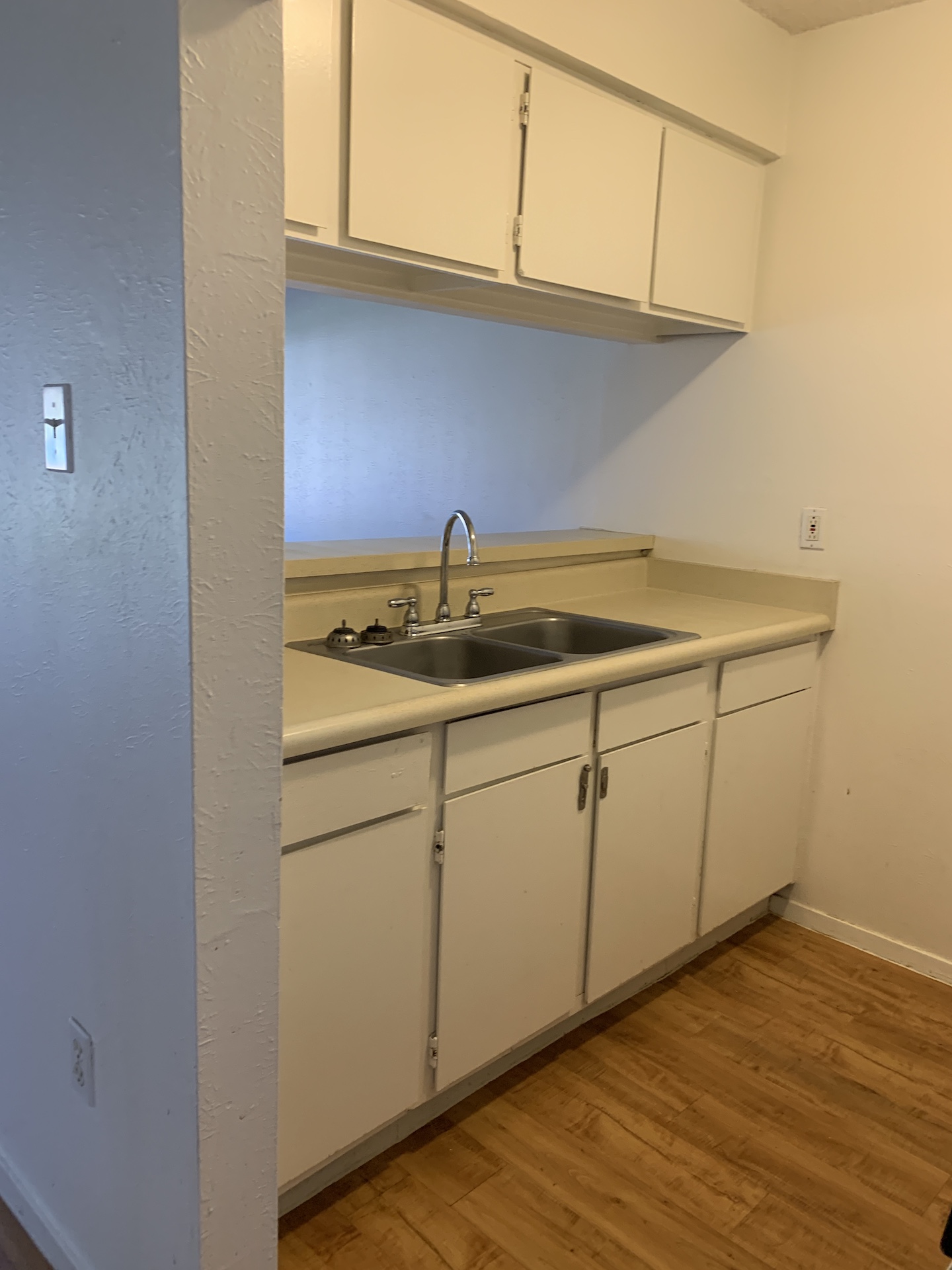 10810 Newmont Road, Unit 3 Austin, TX 78758 - Photo 4 of 8 Kitchen with light countertops, light wood-type flooring, and white cabinetry