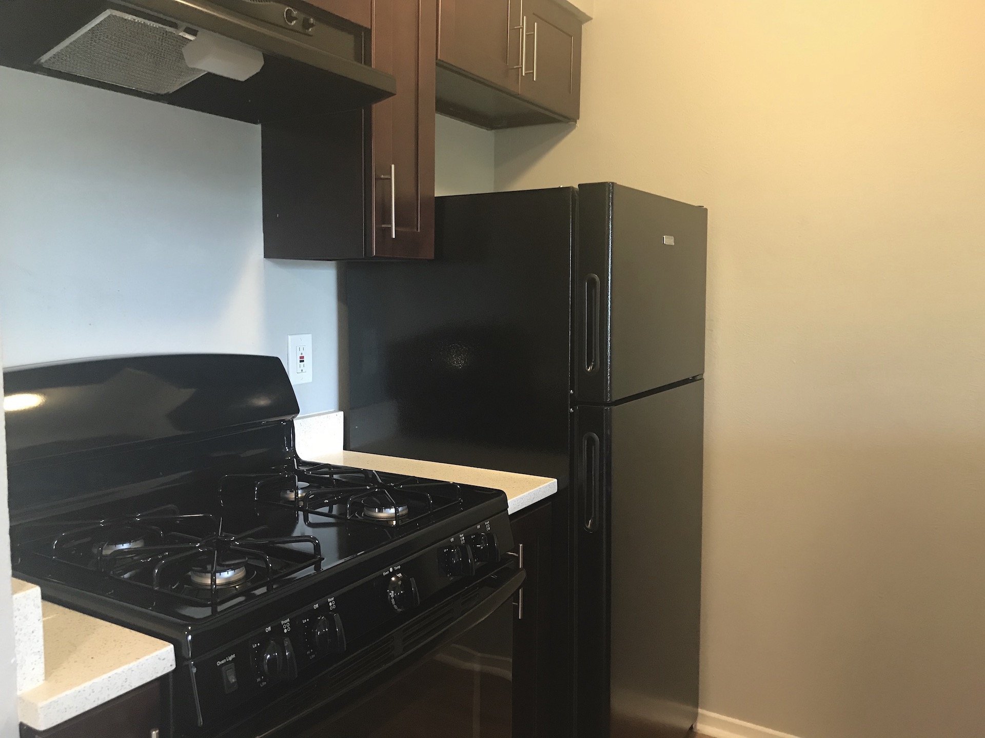 10810 Newmont Road, Unit 3 Austin, TX 78758 - Photo 5 of 8 Kitchen featuring black appliances, range hood, and light countertops