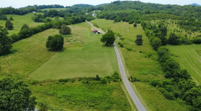 a view of a big house with a big yard and large trees