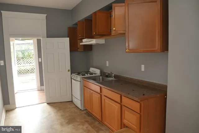 a front view of a house with a tree