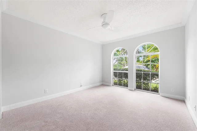 an empty room with windows and chandelier