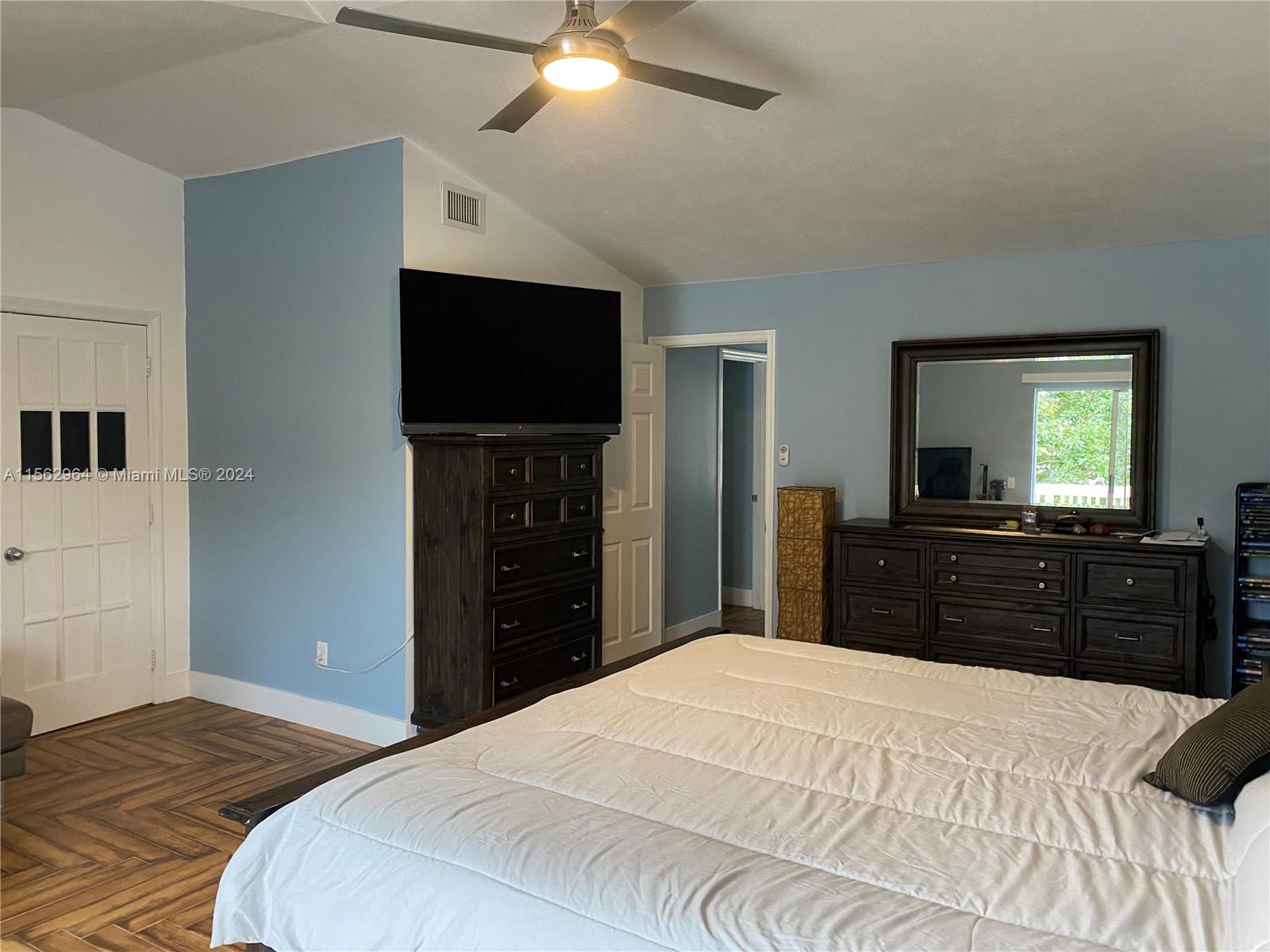 14530 Southwest 142nd Pl Circle Miami, FL 33186 - Photo 15 of 28 a bedroom with a bed and a flat screen tv