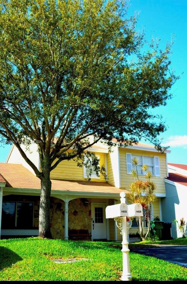 14530 Southwest 142nd Pl Circle Miami, FL 33186 - Photo 2 of 28 a view of a building with a large tree and plants