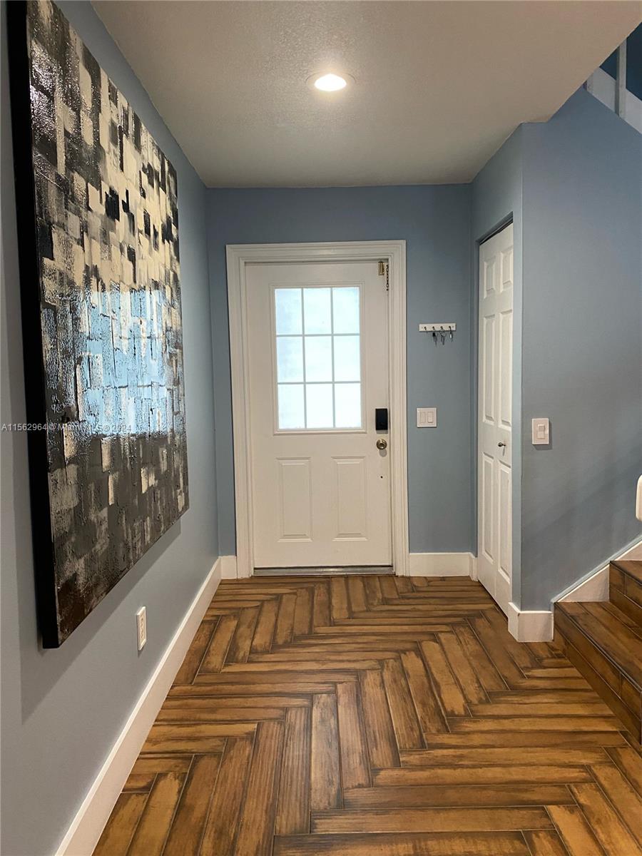 14530 Southwest 142nd Pl Circle Miami, FL 33186 - Photo 3 of 28 a view of a bedroom with wooden floor and a bed