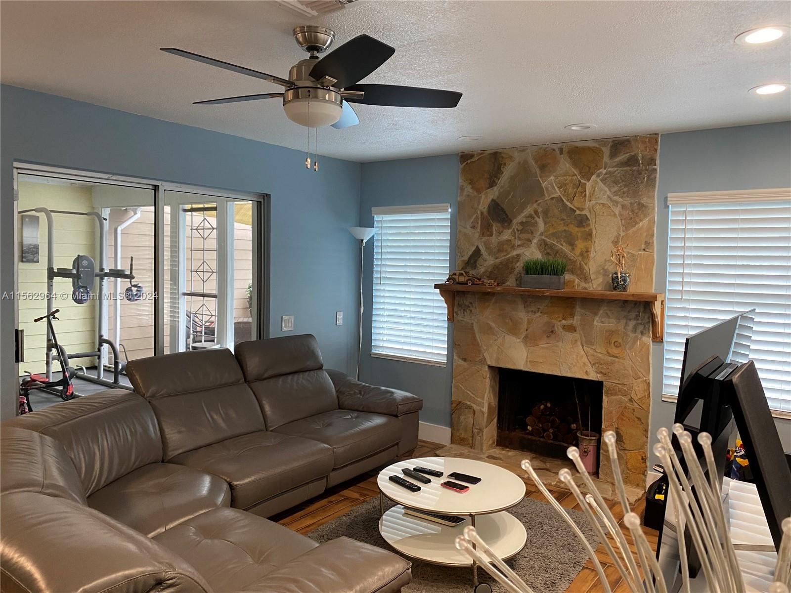 14530 Southwest 142nd Pl Circle Miami, FL 33186 - Photo 4 of 28 a living room with furniture and a fireplace