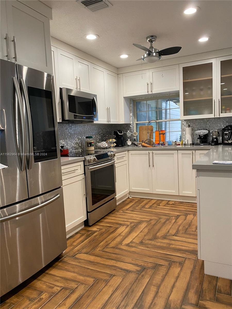 14530 Southwest 142nd Pl Circle Miami, FL 33186 - Photo 8 of 28 a kitchen with granite countertop a refrigerator stove top oven and sink