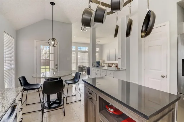 a kitchen with stainless steel appliances granite countertop a sink a stove and a wooden floors