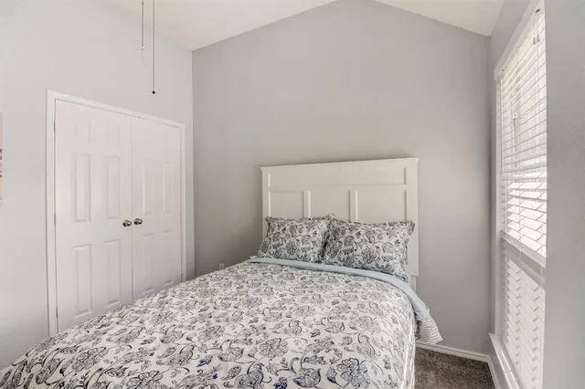 a bedroom with a bed and a window