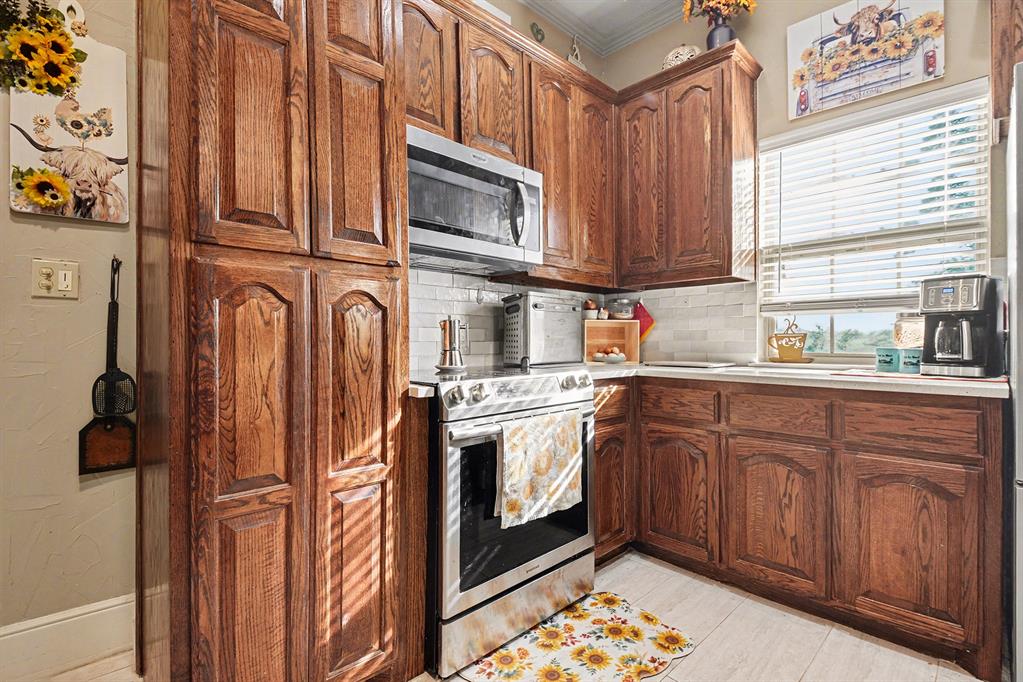 2474 McConnell Road Gunter, TX 75058 - Photo 5 of 17 a kitchen with stainless steel appliances granite countertop a refrigerator and a stove top oven